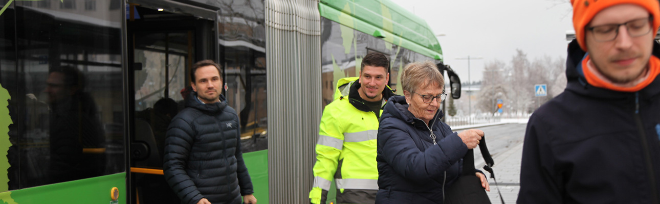 Travellers disembarking a bus through the back door