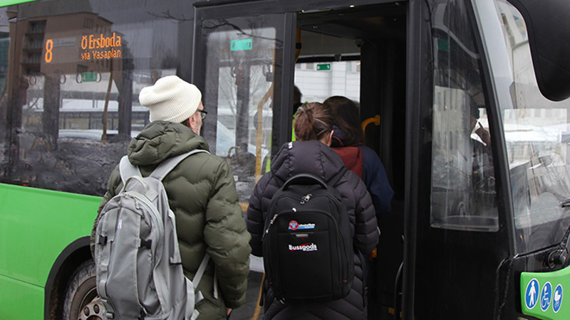 Travellers boarding a bus through the front door